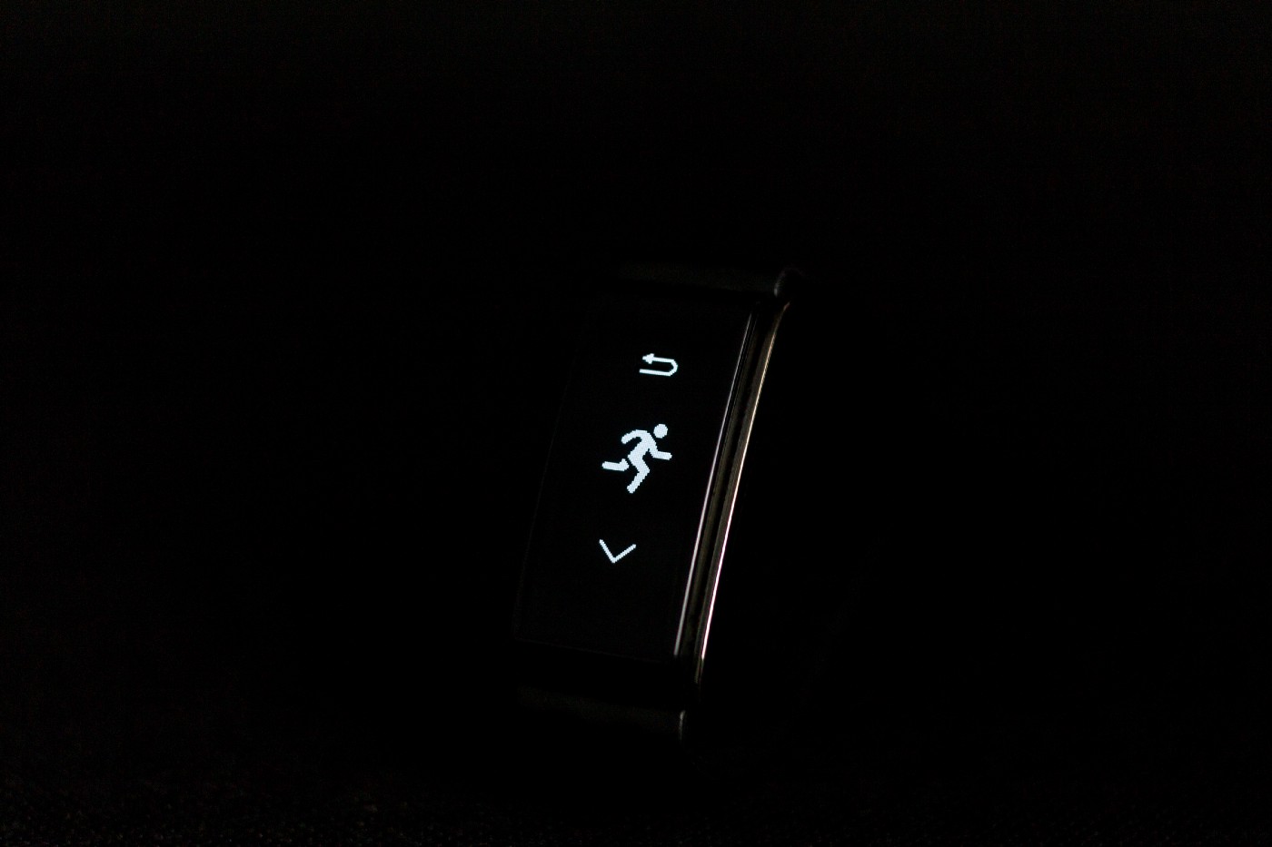 Narrow black pedometer shows a stick figure running. The image is in black and white.