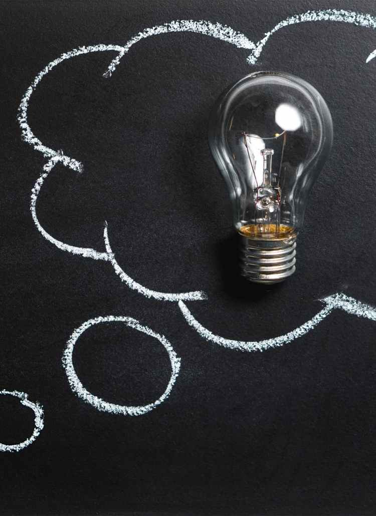 clear light bulb placed on chalkboard