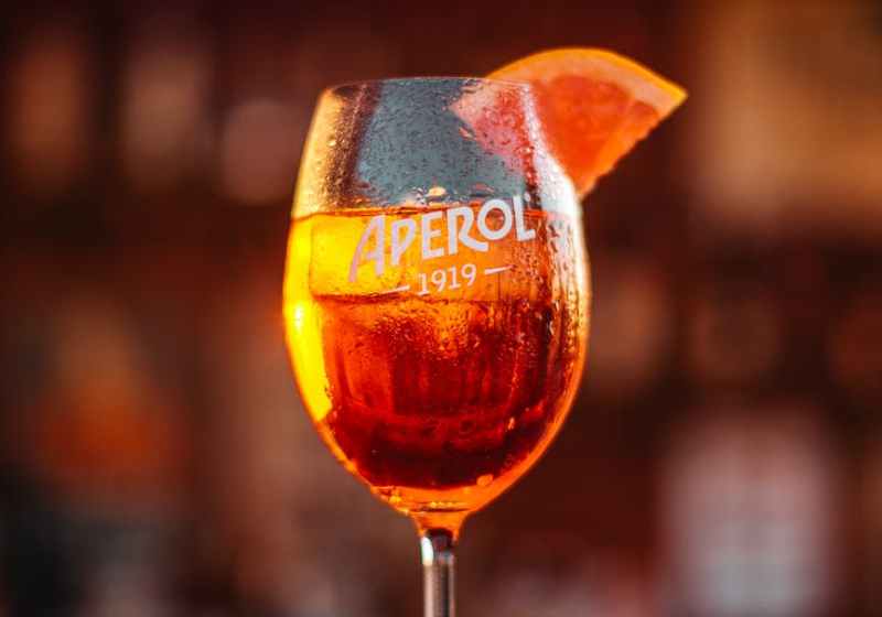glass of bright alcoholic cocktail on table in pub