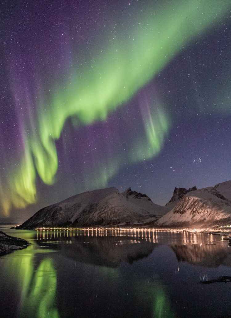 mountain beside body of water with aurora borealis