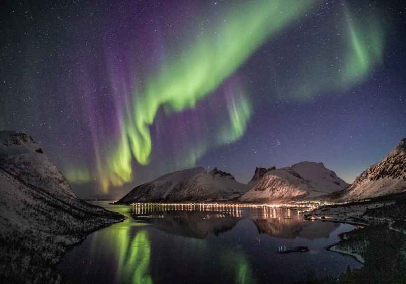 mountain beside body of water with aurora borealis