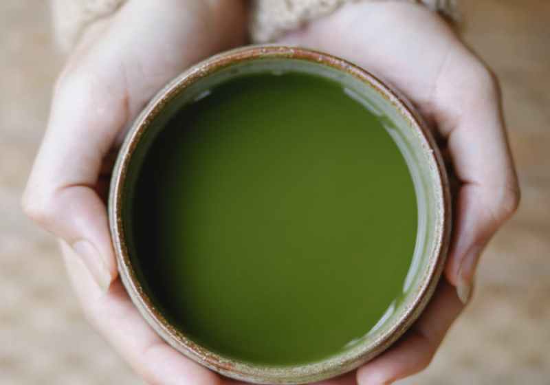 woman demonstrating bowl with traditional green tea