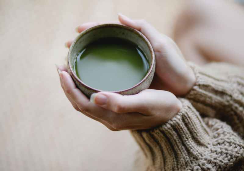 faceless woman with cup of matcha tea
