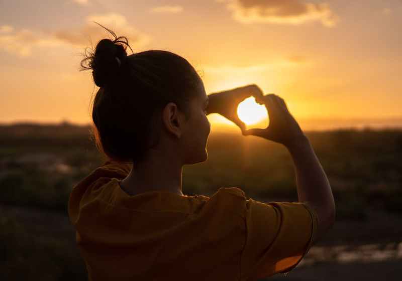 woman doing hand heart sign