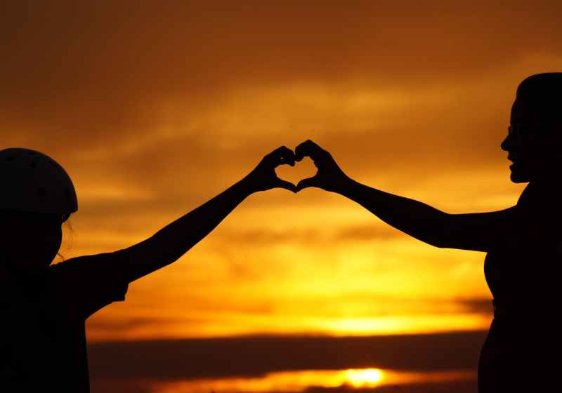 silhouette of man touching woman against sunset sky