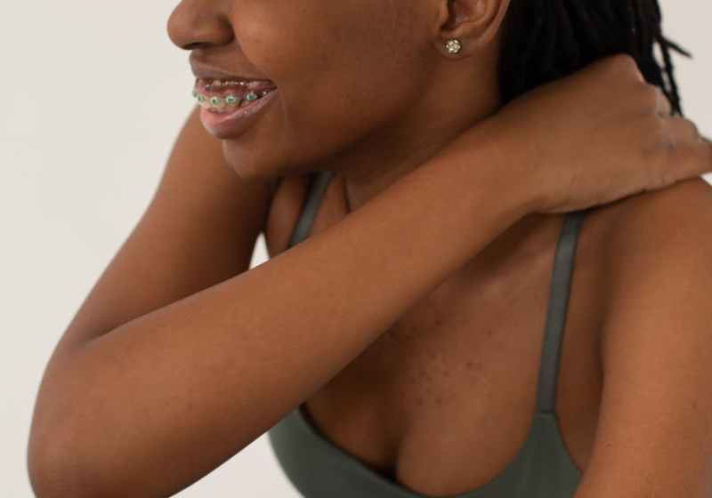 laughing black woman with dreadlocks touching shoulder