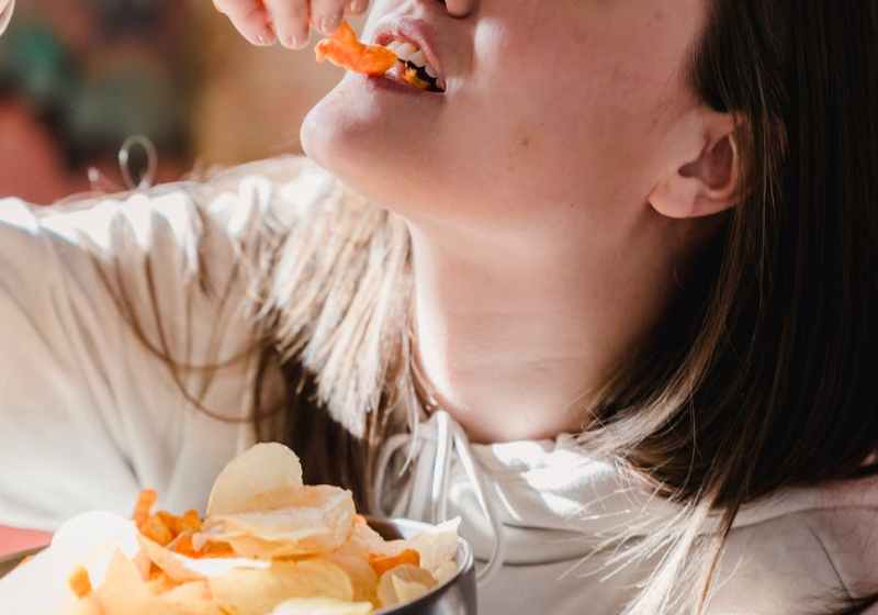 female eating chips at home