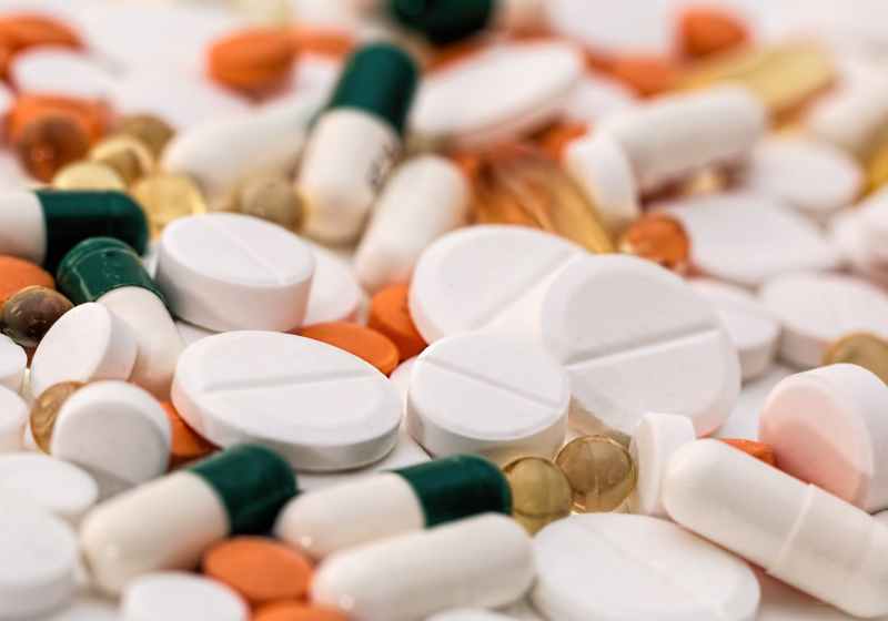 bunch of white oval medication tablets and white medication capsules