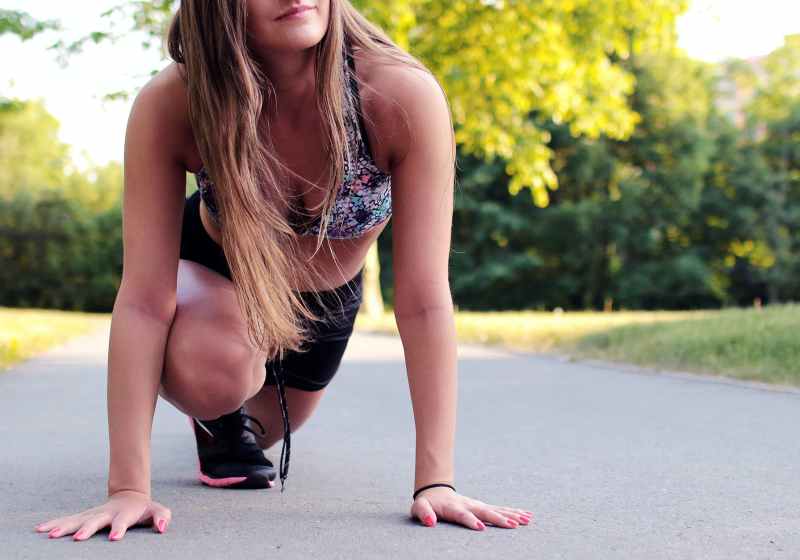 women s wearing purple floral brassiere holding gray concrete pathway during day time