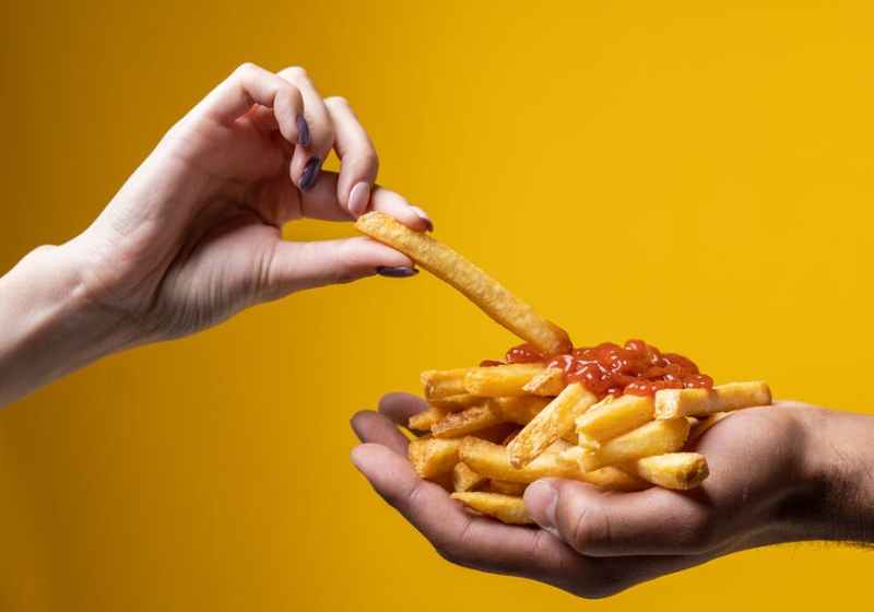 person sharing french fries