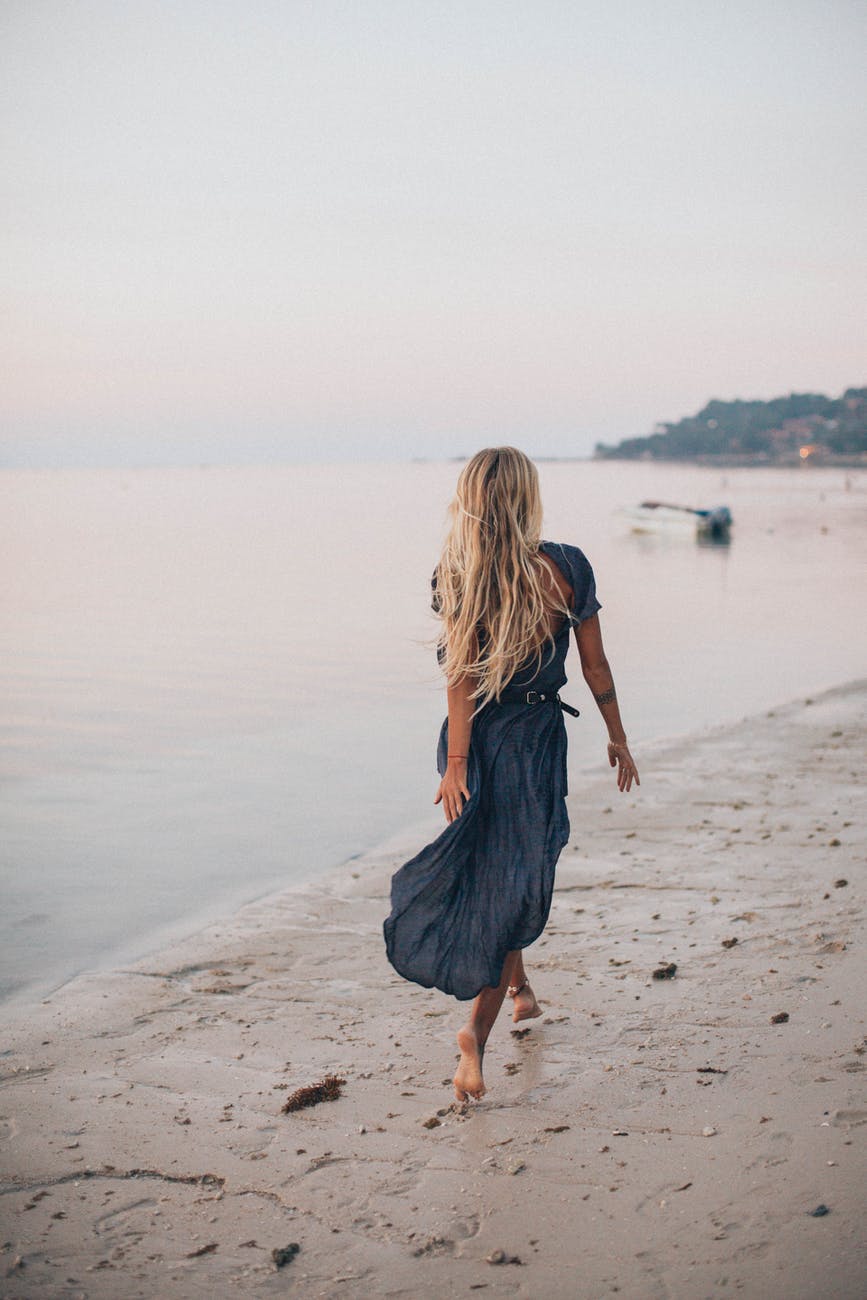 back view of a woman walking on the seashore