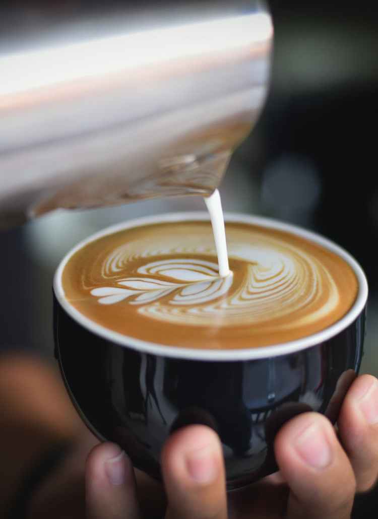 close up of woman holding coffee cup at cafe