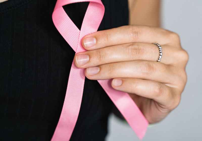 woman in black tank top holding pink ribbon