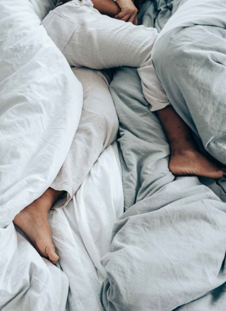crop anonymous person lying in bed