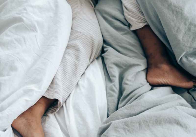 crop anonymous person lying in bed