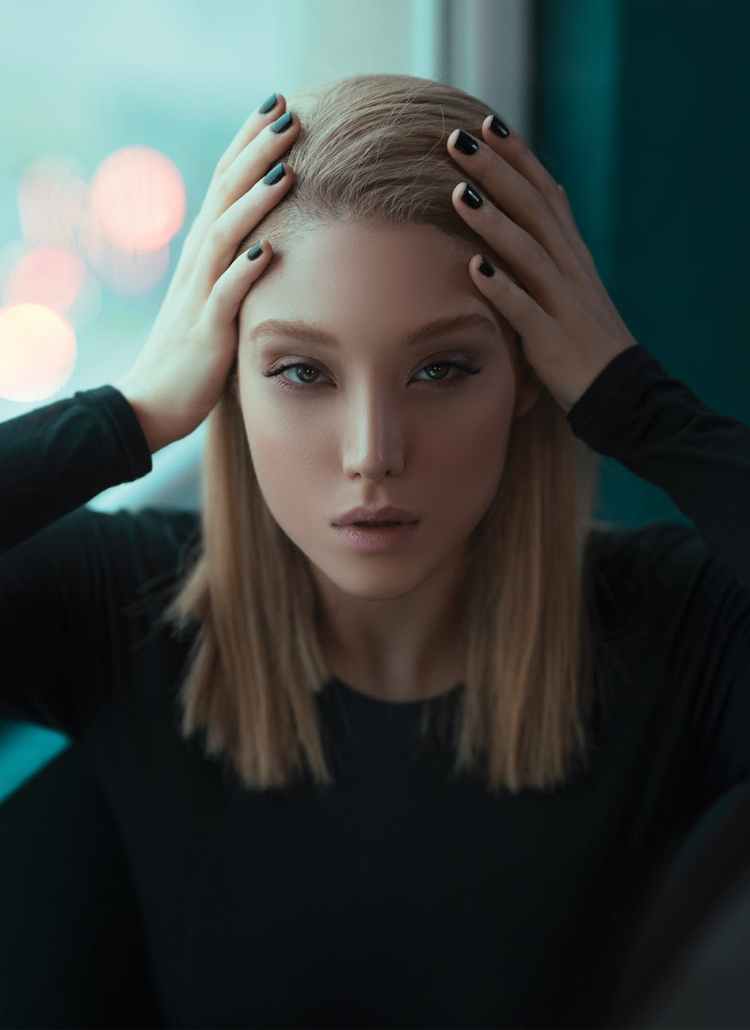 photo of woman holding her head