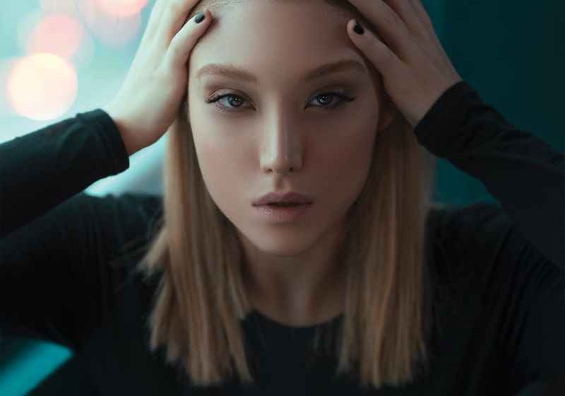 photo of woman holding her head