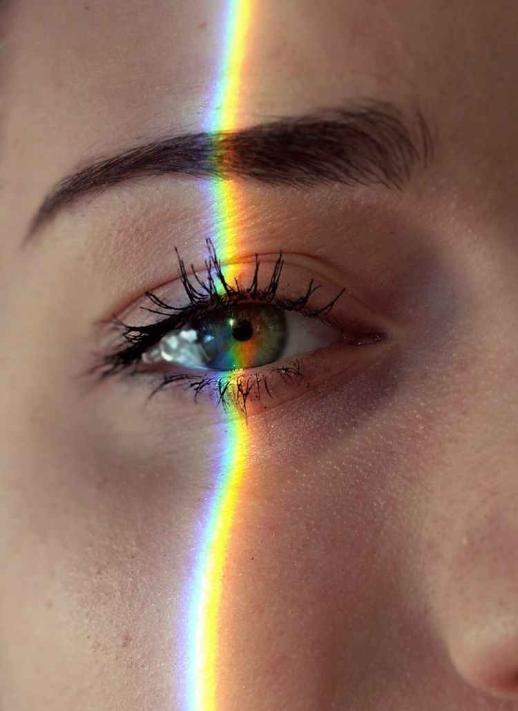 anonymous woman with rainbow light on face