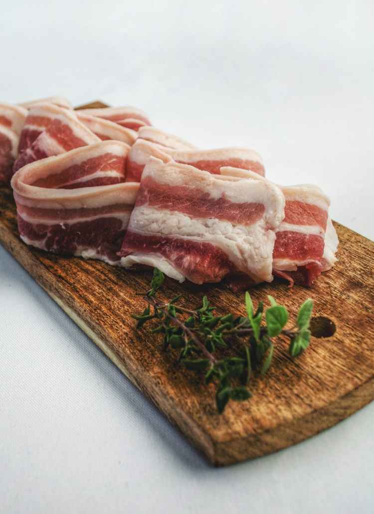 food photography of sliced bacon on top of brown chopping board
