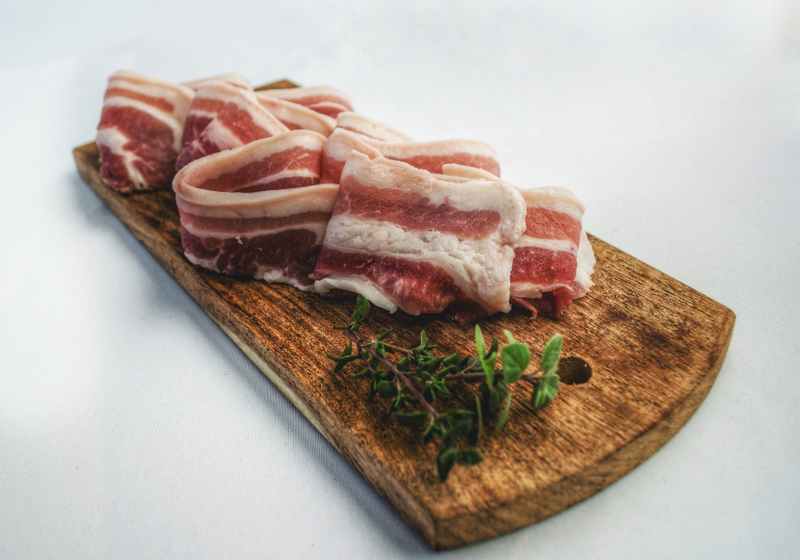 food photography of sliced bacon on top of brown chopping board