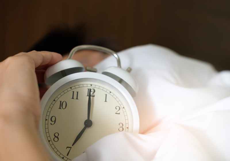 photo of person holding alarm clock