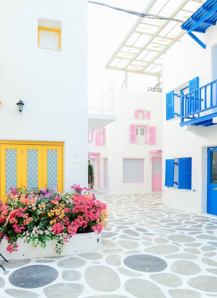 architectural photography of three pink blue and yellow buildings