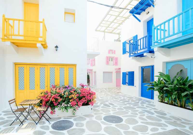architectural photography of three pink blue and yellow buildings