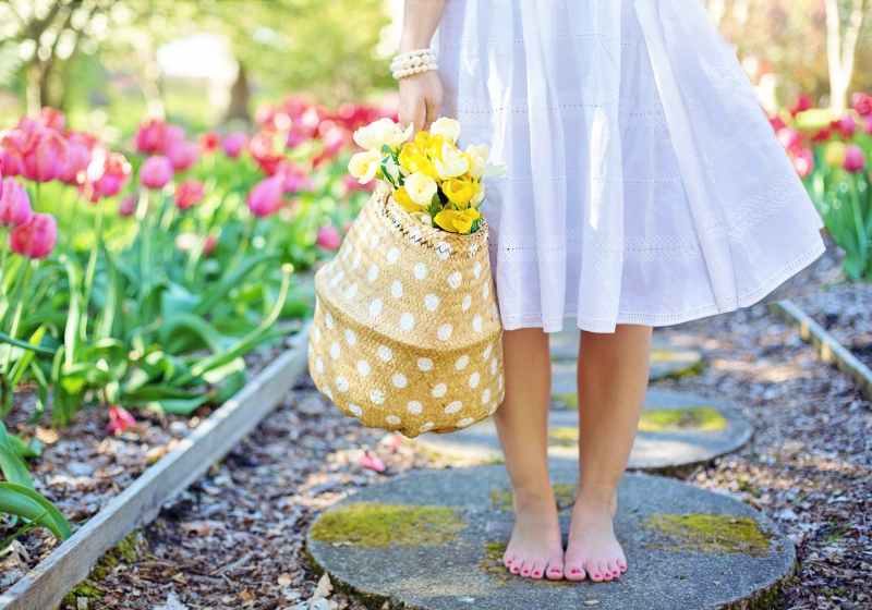 woman holding brown basket with yellow flowers