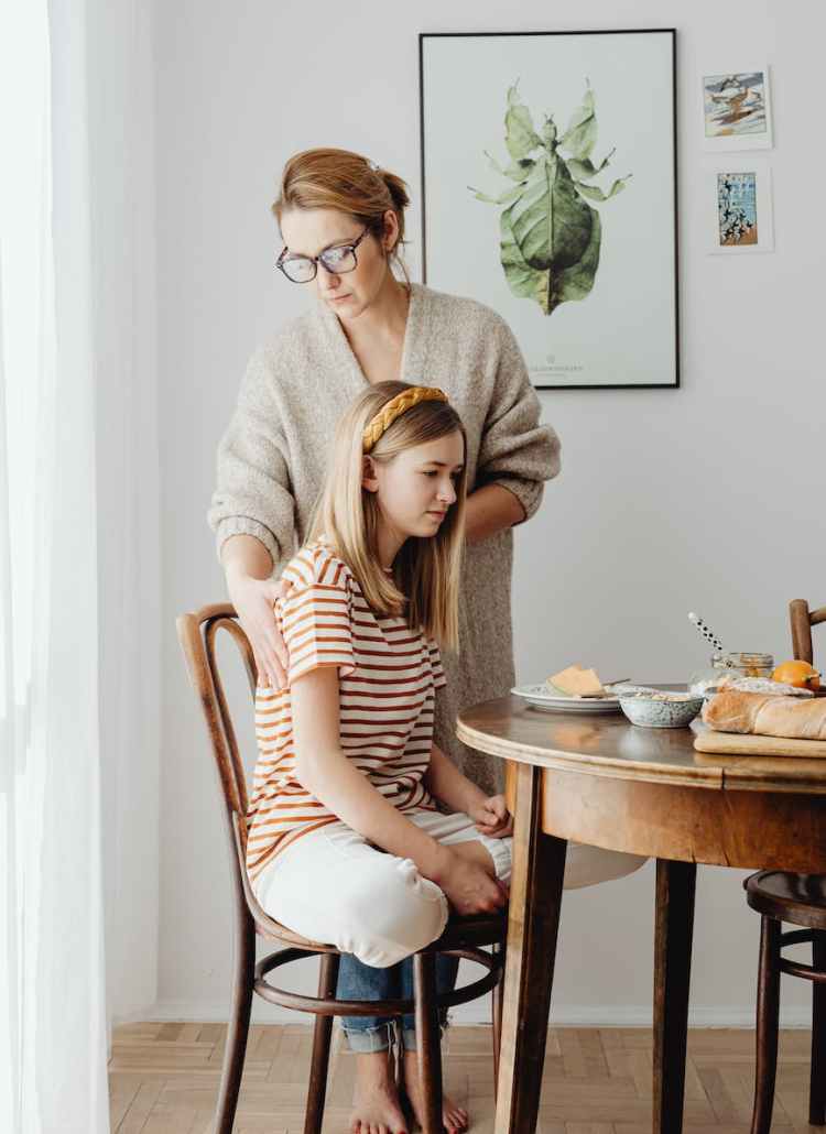 woman fixing daughters posture