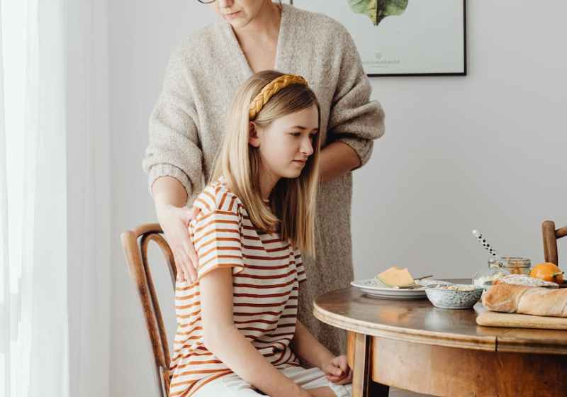 woman fixing daughters posture