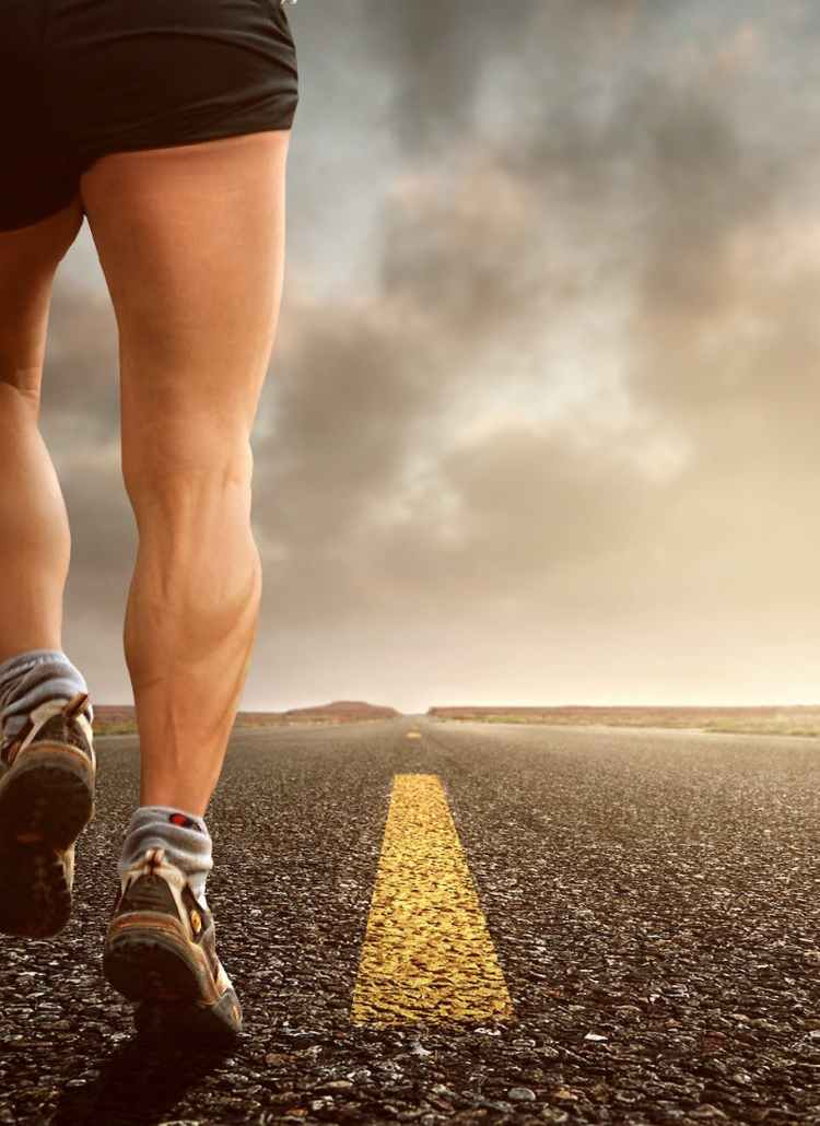 low angle photography man walking on asphalt road