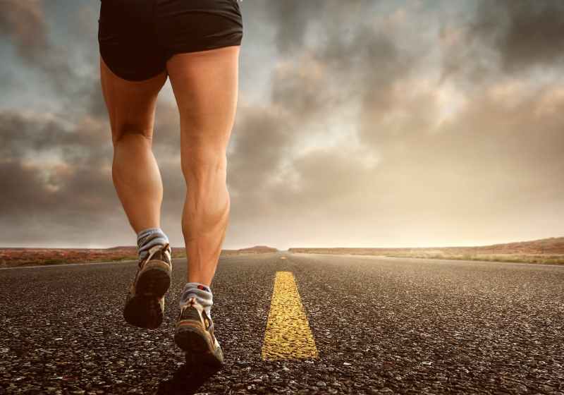 low angle photography man walking on asphalt road