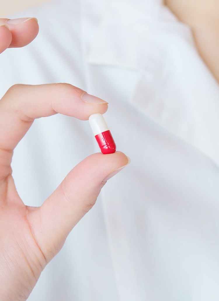 crop nurse demonstrating small double colored pill