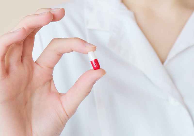 crop nurse demonstrating small double colored pill