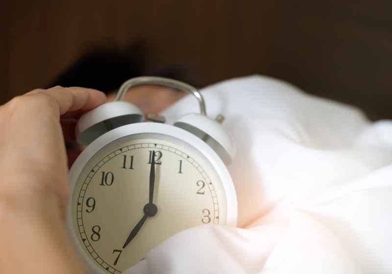 photo of person holding alarm clock