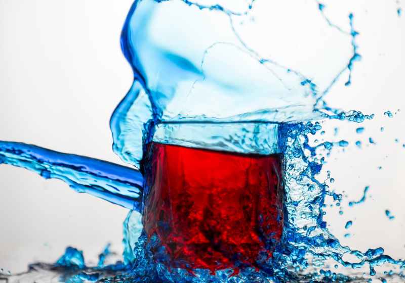 blue clear glass cup splashed of water