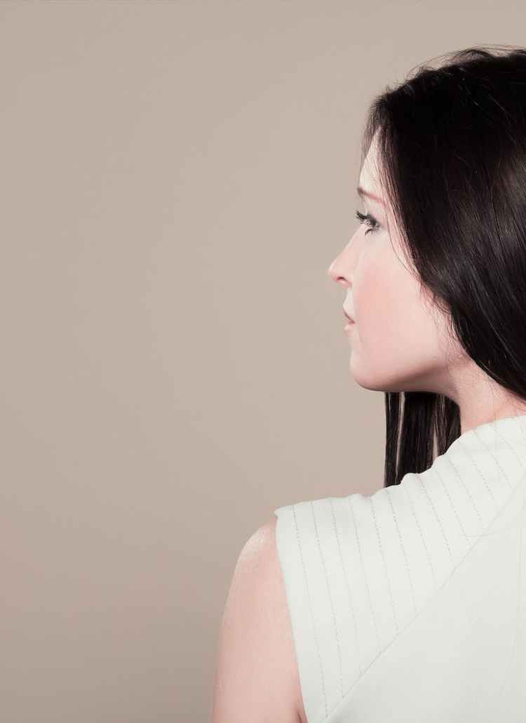 woman in white sleeveless high neck top showing her back