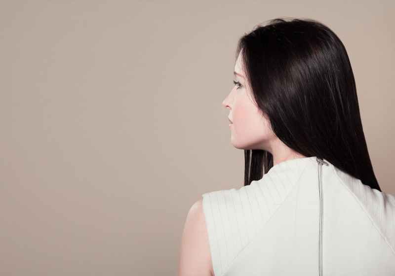 woman in white sleeveless high neck top showing her back