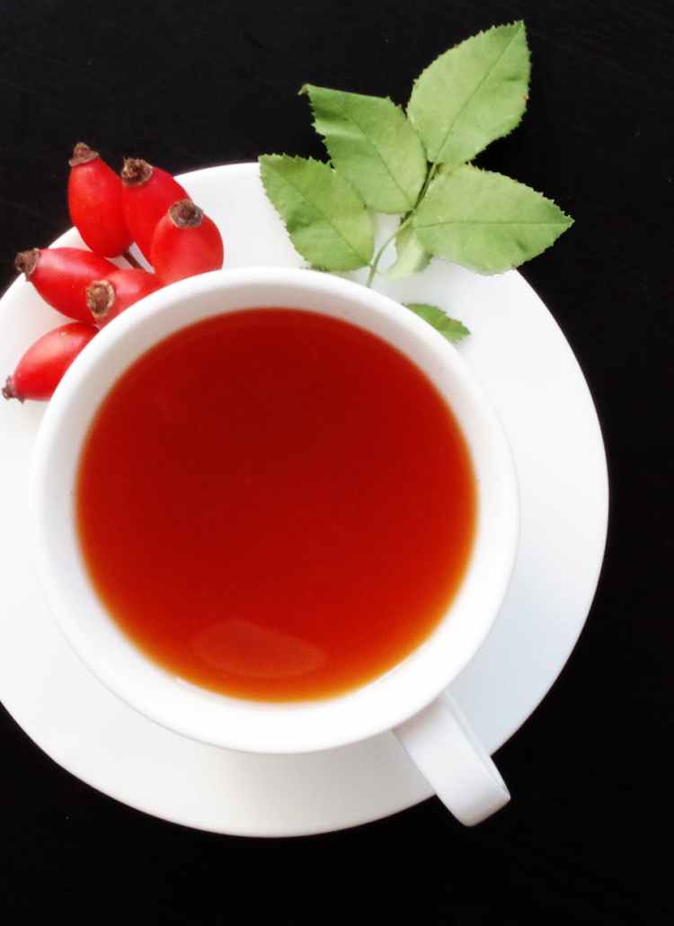 white cup filled with orange liquid on top of white saucer