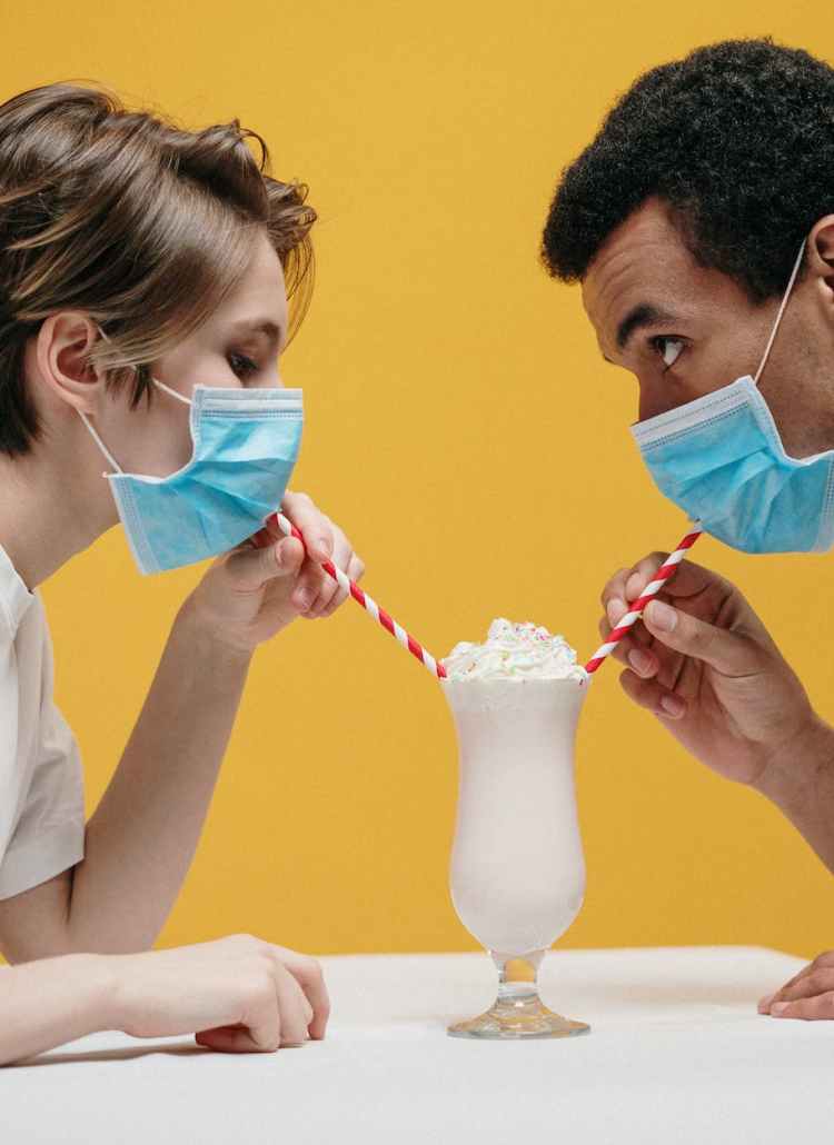 couple wearing face mask drinking milkshake