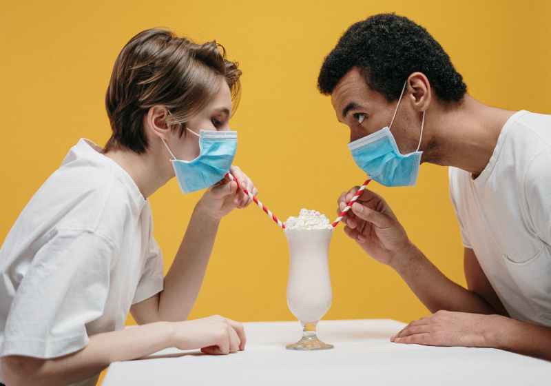 couple wearing face mask drinking milkshake