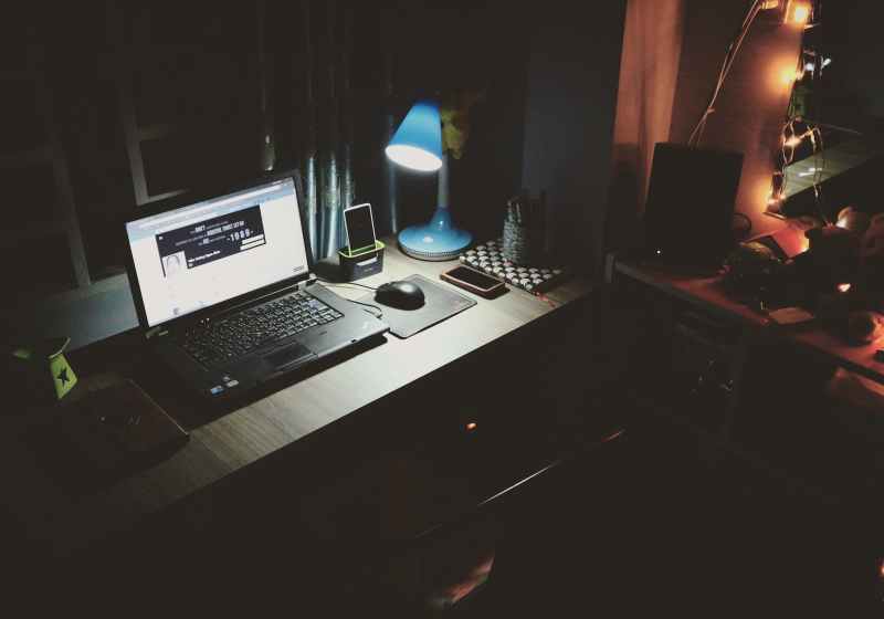 black laptop beside black computer mouse inside room
