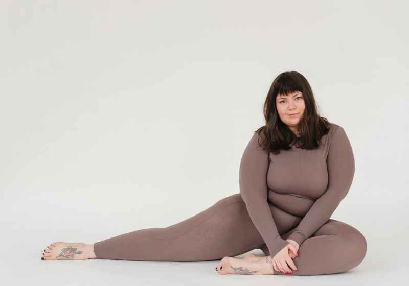 overweight woman in activewear sitting in studio during training