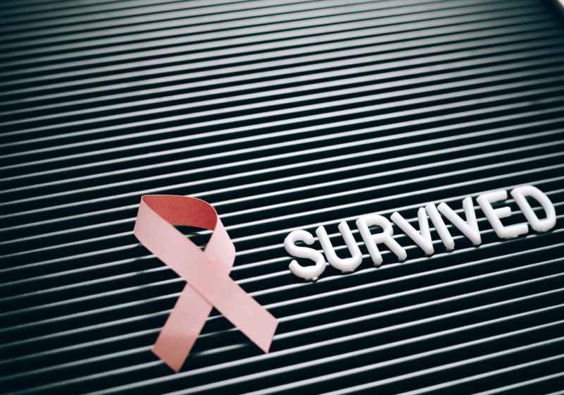 a pink ribbon beside a note on a letter board