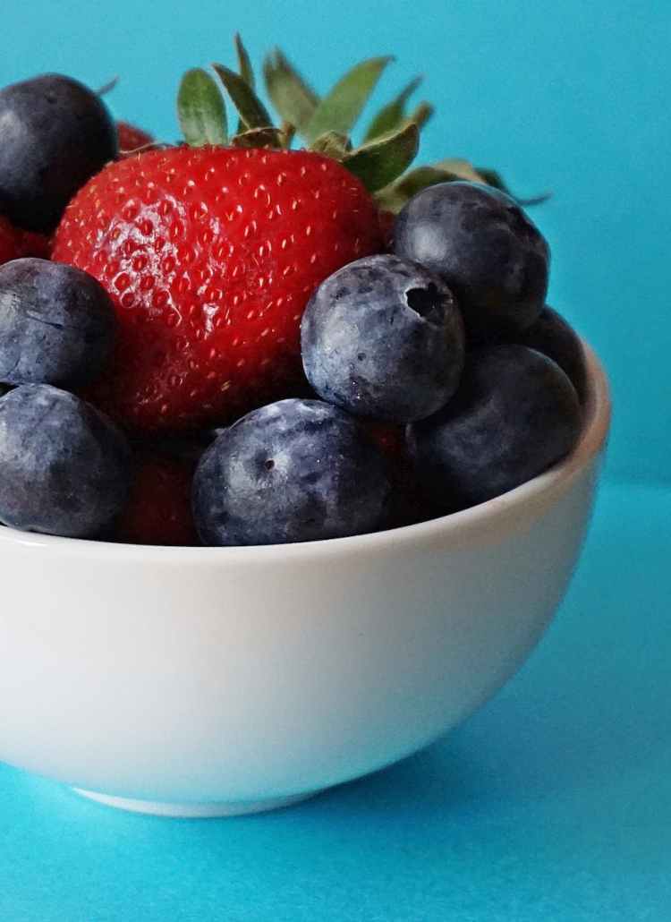 blueberries and strawberries in white ceramic bowl