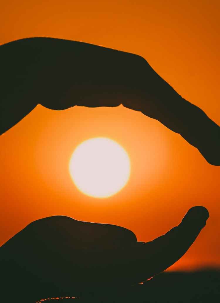 silhouette of person s hands during sunset