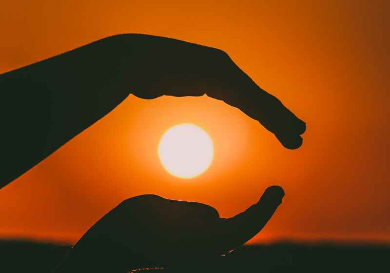 silhouette of person s hands during sunset