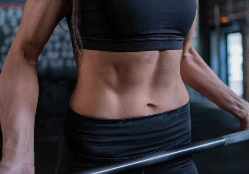 woman in black sportswear lifting a barbell