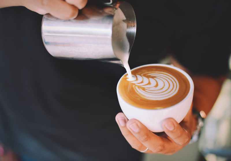 person holding white cup