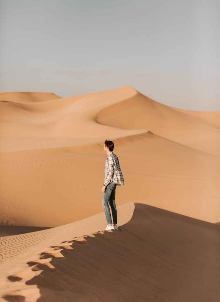 photo of man standing on desert